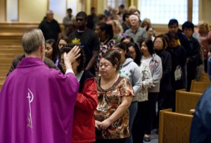 Members of the congregation form a line in front of Rev. Theodore Olson as he places ash on foreheads during Ash Wednesday mass at St. Pius V Catholic Church in Buena Park early Wednesday morning. ADDITIONAL INFO: ashweds - 02/17/10 - Photo by MARK RIGHTMIRE, THE ORANGE COUNTY REGISTER